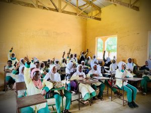 Students raise hands and ask questions during an interactive classroom learning session.